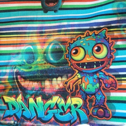Detalle de la tela de algodón con monstruos de colores sonrientes y expresivos.