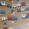 Primer plano del tejido exterior de algodón con estampado de trenes en tonos marrón, azul y rojo.