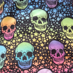 Detalle del tejido estampado con calaveras fluor en tonos vivos sobre fondo negro.